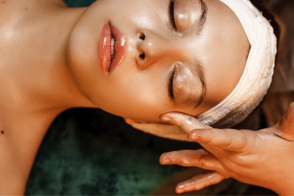 Close-up image of a female client receiving a hyaluronic acid facial from an esthetician at a spa.