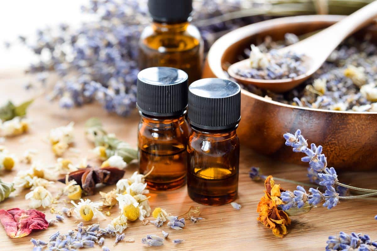 aromatherapy oils on table surrounded by dried flowers